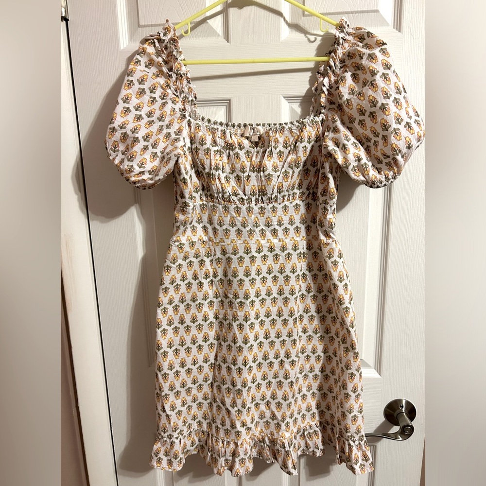 White and pattern dress. Tight around the bust and flows out.